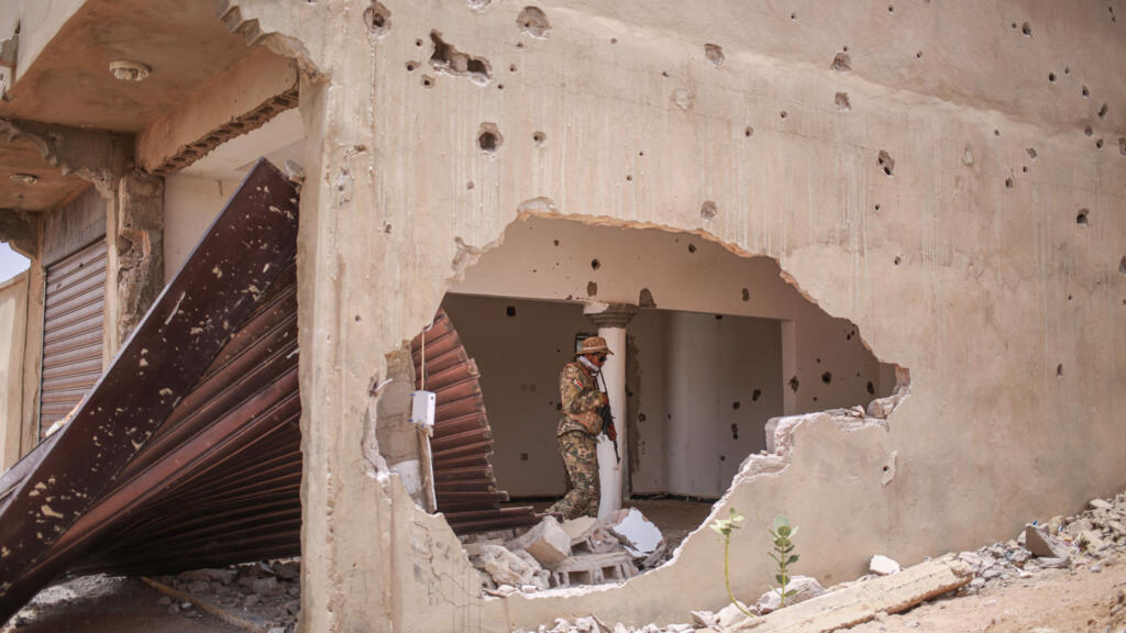 A soldier from the National Liberation Front of Azawad (FLA) walks inside a damaged building in Kidal on May 9, 2026.